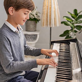a boy with instant access premium membership playing piano