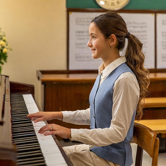 8 advantages of online piano lessons rather than this young woman playing in a schoolroom