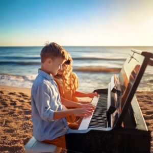 A boy and girl playing piano on a beach. the power of music exoplained